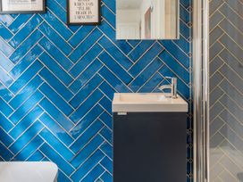 A bathroom with a sink, mirror, and shower at The Sundial in St Austell