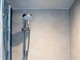 A shower with a chrome shower head in a bathroom at The Sundial in St Austell