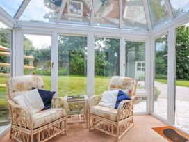 A conservatory with rattan chairs and a table at Upper Court Cottage Broad Langdon near Wainhouse Corner