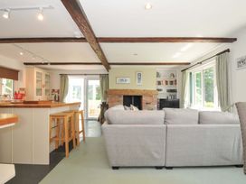 A living room with a fireplace and kitchen island at Upper Court Cottage Broad Langdon near Wainhouse Corner