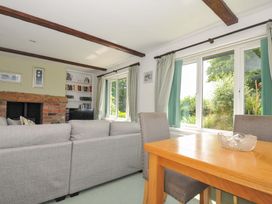 A living room with a sofa and dining table at Upper Court Cottage in Broad Langdon near Wainhouse Corner
