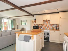 A kitchen with a counter, appliances, and a dining area at Upper Court Cottage in Broad Langdon near Wainhouse Corner