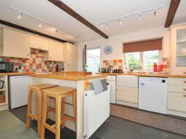 A kitchen with an island and stools at Upper Court Cottage Broad Langdon near Wainhouse Corner