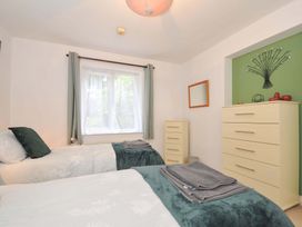 A bedroom with two beds and a dresser at Upper Court Cottage in Broad Langdon near Wainhouse Corner