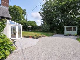 A garden with a conservatory and a shed at Upper Court Cottage in Broad Langdon near Wainhouse Corner