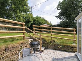 A garden with a grill and patio furniture at Upper Court Cottage in Broad Langdon near Wainhouse Corner
