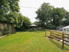 A garden with chairs and an umbrella at Upper Court Cottage Broad Langdon near Wainhouse Corner