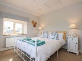 A bedroom with a bed and nightstands at Criw in Bryncroes near Sarn Meyllteyrn