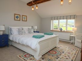 A bedroom with a bed and side tables at Criw in Bryncroes near Sarn Meyllteyrn