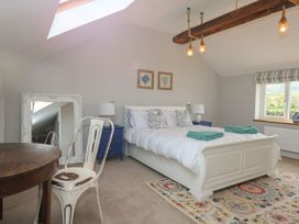 A bedroom with a bed, table, and chair at Criw in Bryncroes near Sarn Meyllteyrn