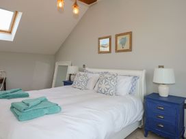A bedroom with a bed and blue furniture at Criw in Bryncroes near Sarn Meyllteyrn