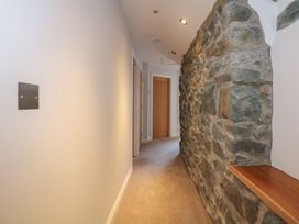 A hallway with a stone wall and doors at Criw in Bryncroes near Sarn Meyllteyrn