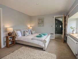 A bedroom with a bed and wooden furniture at Criw Bryncroes near Sarn Meyllteyrn
