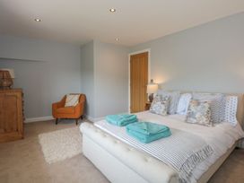 A bedroom with a bed and a chair at Criw Bryncroes near Sarn Meyllteyrn