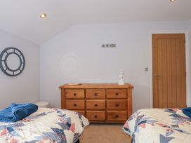 A bedroom with two single beds and a wooden dresser at Criw in Bryncroes near Sarn Meyllteyrn