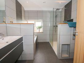 A bathroom with a shower and sink at Criw in Bryncroes near Sarn Meyllteyrn