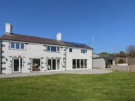 An outdoor view of a modern house with windows and grass at Criw in Bryncroes near Sarn Meyllteyrn