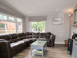 A living room with a brown sofa and table at Owls Nook Lodge Langdale 9 White Cross Bay near Windermere