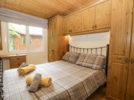 A bedroom with a bed and wardrobe at Owls Nook Lodge, Langdale 9, White Cross Bay near Windermere