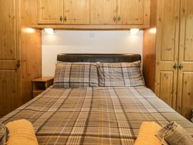 A bedroom with a bed and wardrobes at Owls Nook Lodge, Langdale 9, White Cross Bay near Windermere