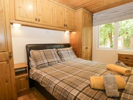 A bedroom with a bed and towels at Owls Nook Lodge Langdale 9, White Cross Bay near Windermere