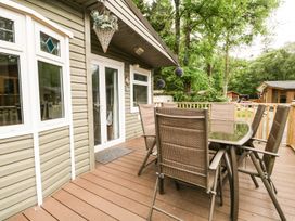 An outdoor seating area with a table and chairs at Owls Nook Lodge, Langdale 9, White Cross Bay near Windermere