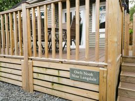 An outdoor deck area with a table and chairs at Owls Nook Lodge, Langdale 9, White Cross Bay near Windermere
