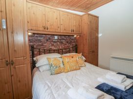 A bedroom with a bed and wardrobe at Owls Nook Lodge, Langdale 9, White Cross Bay near Windermere
