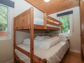A bedroom with a bunk bed and a double bed at Owls Nook Lodge, Langdale 9, White Cross Bay near Windermere
