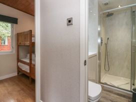 A bathroom with a shower and a bunk bed at Owls Nook Lodge Langdale 9, White Cross Bay near Windermere