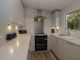 A kitchen with a sink and oven at Owls Nook Lodge Langdale 9 White Cross Bay near Windermere