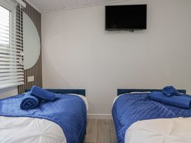 A bedroom with two beds and a television at Owls Nook Lodge Langdale 9, White Cross Bay near Windermere