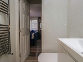 A bathroom with a sink and door to another room at Owls Nook Lodge in Langdale 9, White Cross Bay near Windermere