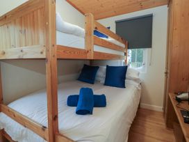 A bedroom with a bunk bed and a double bed at Owls Nook Lodge Langdale 9 White Cross Bay near Windermere
