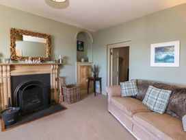 A living room with a sofa and fireplace at Zenobia in New Quay