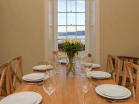 A dining room with a table set for a meal at Zenobia in New Quay
