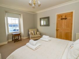 A bedroom with a bed and towels on the bed at Zenobia in New Quay