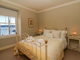 A bedroom with a bed and bedside tables at Zenobia in New Quay