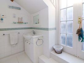 A bathroom with a sink and towel rack at Zenobia in New Quay