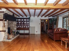 A living room with a fireplace and wooden beams at Higher Wadden Farm in Southleigh