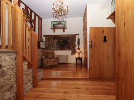A hallway with wood features and a chandelier at Higher Wadden Farm Southleigh