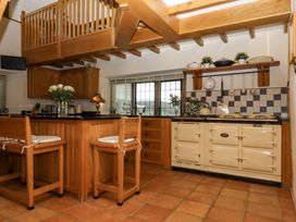 A kitchen with an island and seating at Higher Wadden Farm in Southleigh