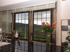 A kitchen with a window overlooking the countryside at Higher Wadden Farm Southleigh