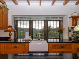 A kitchen with a sink and window overlooking greenery at Higher Wadden Farm Southleigh