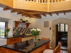 A kitchen with an island and window at Higher Wadden Farm in Southleigh