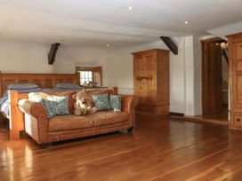 A bedroom with beds and a sofa at Higher Wadden Farm in Southleigh