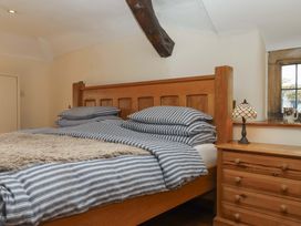 A bedroom with a wooden bed and lamp at Higher Wadden Farm Southleigh