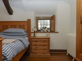A bedroom with a bed and nightstand at Higher Wadden Farm in Southleigh