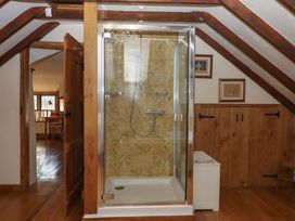 A bathroom with a shower and wooden elements at Higher Wadden Farm in Southleigh