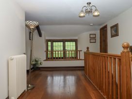 A hallway with a lamp, radiator, and handrail at Higher Wadden Farm in Southleigh